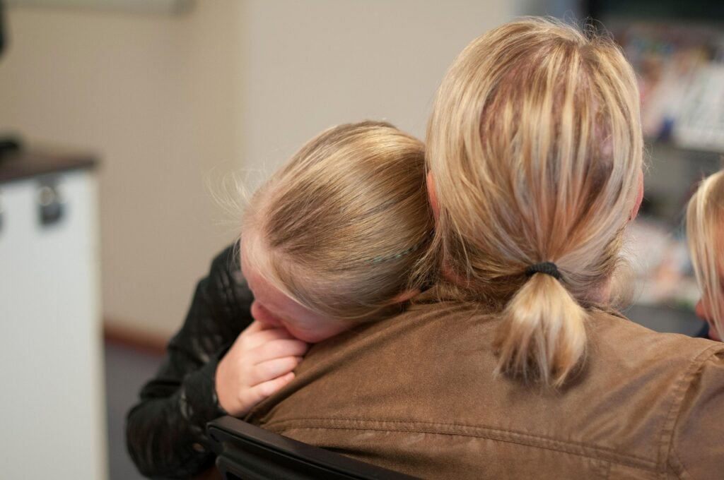 A mother comforts her upset child with a gentle hug